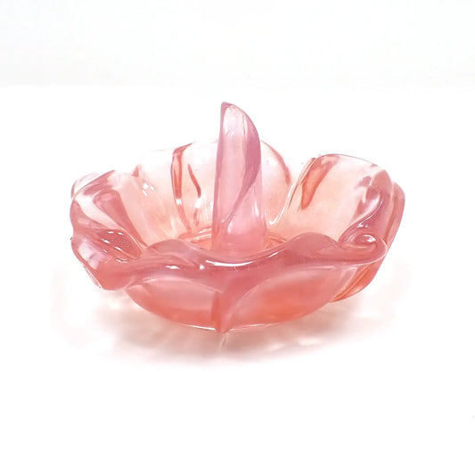 Side view of the handmade resin flower ring dish holder. It's shaped like an open flower with a petal sticking up in the middle for rings to go on. It is translucent light red and purple in color. 