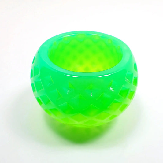 Side view of the small handmade resin succulent pot. It is round shaped the an indented diamond shape pattern design all the way around it. There is bright green at the top and lighter bright green at the bottom.