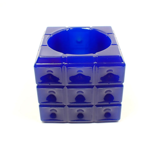 Angled photo of the handmade resin trinket dish. The resin is opaque royal blue in color. The dish is cube shaped with a square pattern all the way around the edge. The top has a round open area to put small things.