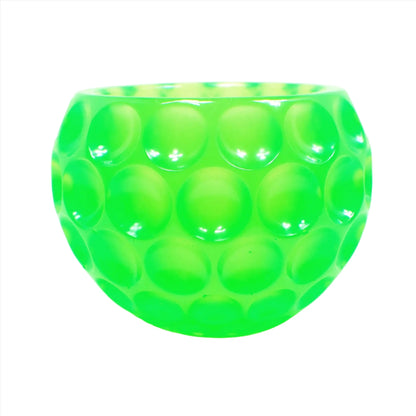 Side view of the handmade resin decorative bowl. The resin is bright neon green in color. The bowl is rounded and has an indented dot design all the way around it.