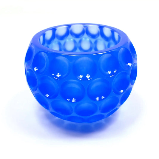 Side view of the handmade resin decorative bowl. The resin is semi translucent neon blue in color. The bowl is rounded and has an indented dot design all the way around it.