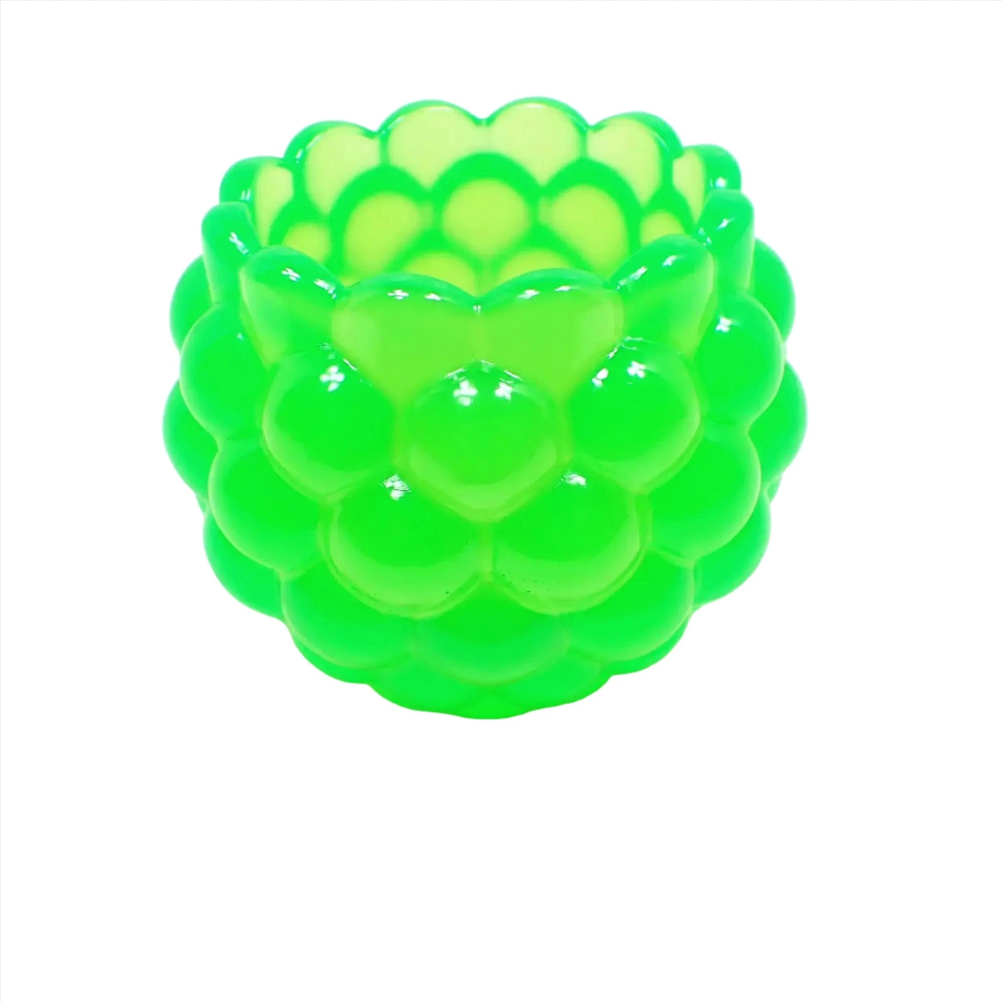 Side view of the handmade resin decorative bowl. The resin is bright neon green in color. It has a rounded shape with a bumpy round ball textured on the outside. The top tapers slightly and has a scalloped edge.