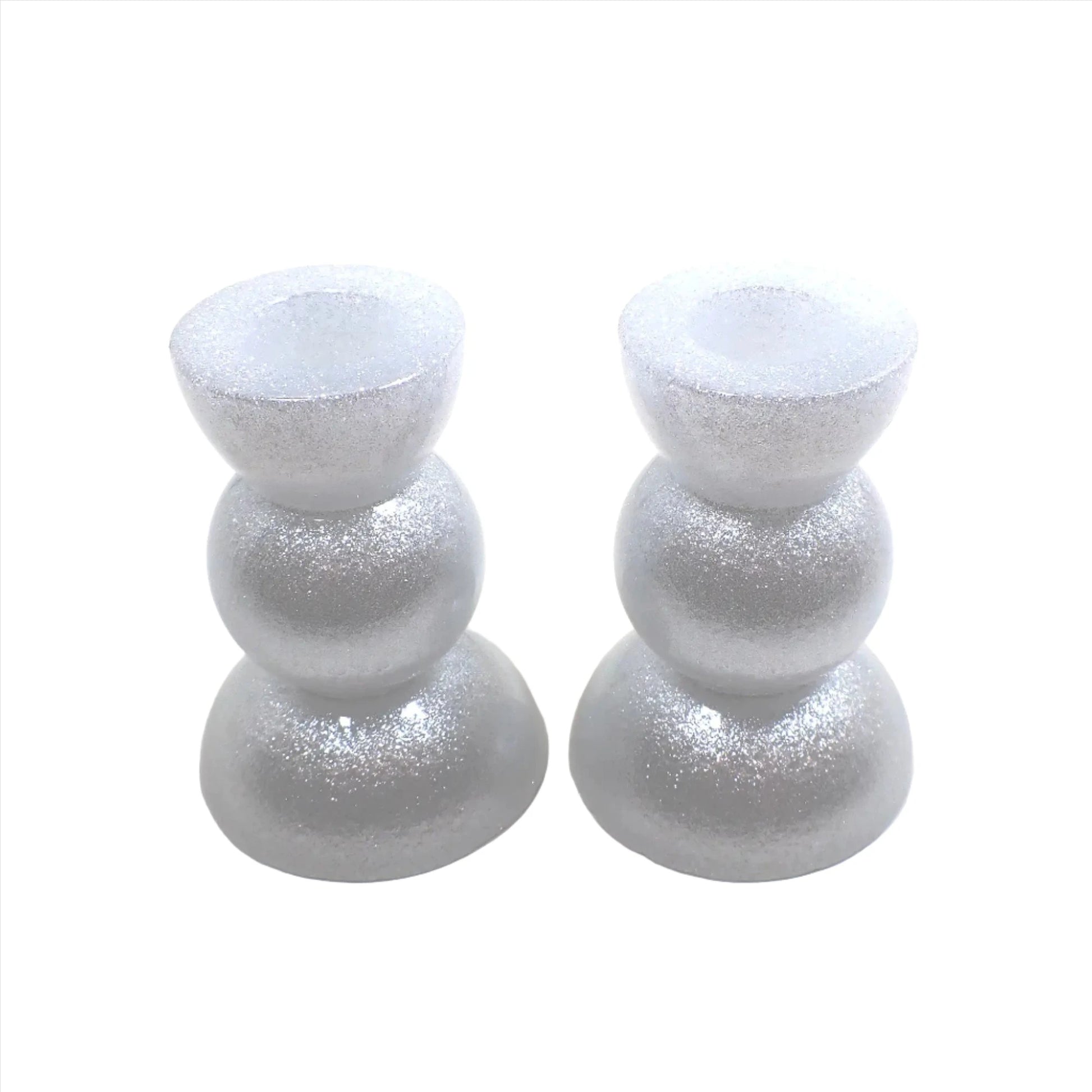Side view of the handmade geometric candlestick holders. They have three rounded areas with a flared out top and bottom. The resin is sparkly white in color.