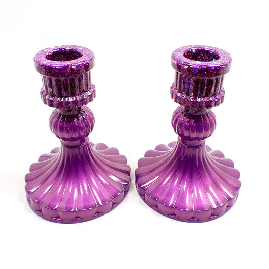 Side view of the handmade vintage style resin candlestick holders. They have pearly lilac color resin on the bottom and iridescent glitter on top. They have a corrugated appearance with a flared out round bottom.