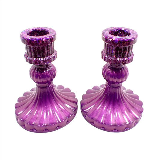 Side view of the handmade vintage style resin candlestick holders. They have pearly lilac color resin on the bottom and iridescent glitter on top. They have a corrugated appearance with a flared out round bottom.