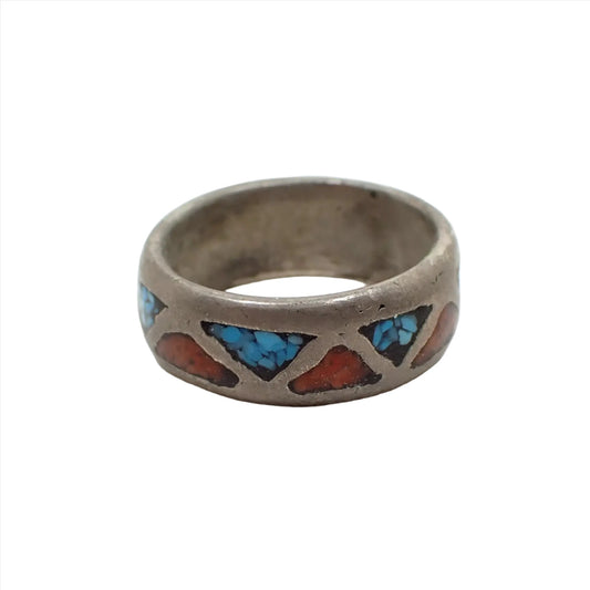 Front view of the retro vintage Southwestern style band ring. It is dark silver in color with alternating red and blue triangle design that has resin with imitation stone chips.