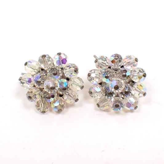 Front view of the Mid Century AB crystal cluster beaded clip on earrings. The beads are faceted round shape and are clear with flashes of color as the light hits them. The metal is silver tone in color.