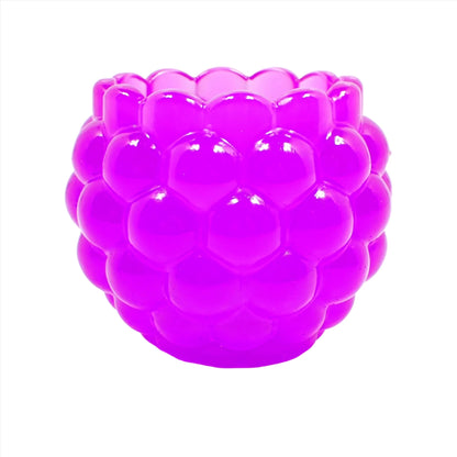 Side view of the handmade resin decorative bowl. The resin is neon purple in color. It has a rounded shape with a bumpy round ball textured on the outside. The top tapers slightly and has a scalloped edge.