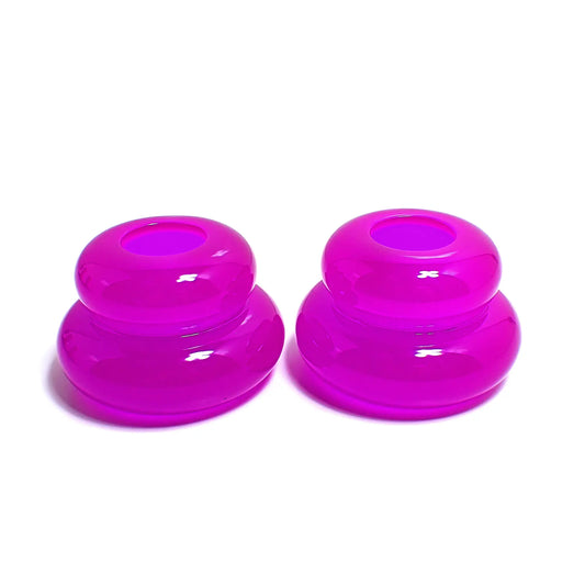 Side view of the pair of handmade double ring candlestick holders. They are shaped like puffy donut rings with a larger one on bottom and a smaller one on top. The resin is neon purple in color. There is a round hole at the top for the candlesticks to go in.