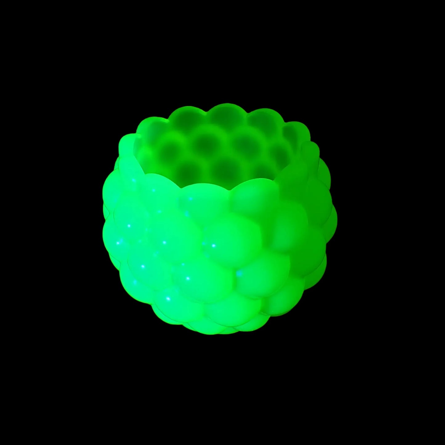 Photo showing the handmade neon yellow resin scalloped bowl fluorescing bright green under a UV light.