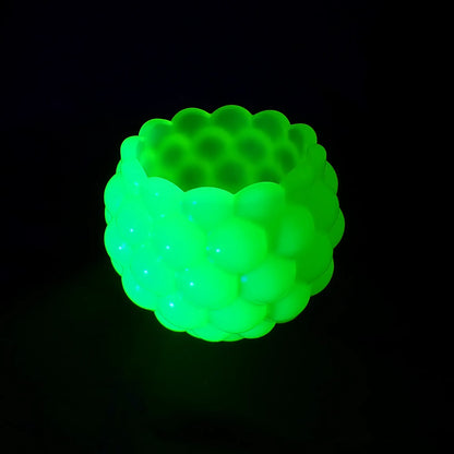 Photo showing the handmade resin scalloped bowl fluorescing bright green under a UV light.