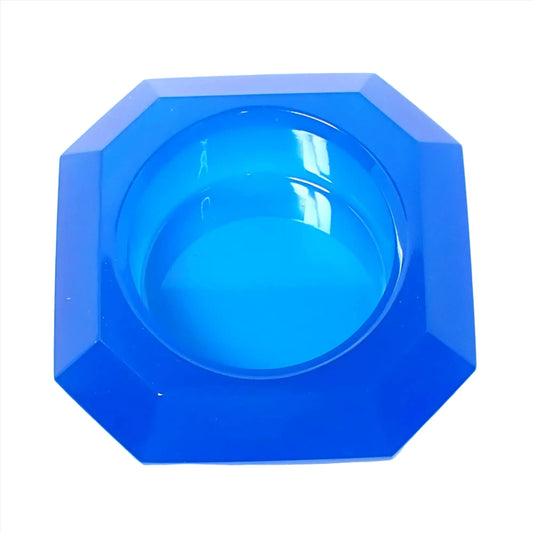 Top view of the small handmade octagon faceted decorative bowl. The resin is semi translucent neon blue. It has a round area in the middle for putting small succulents or tiny objects.