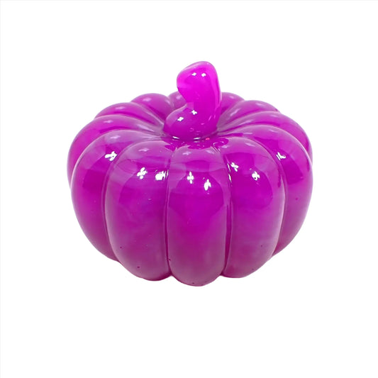 Side view of the small handmade resin pumpkin. It is bright purple in color with some marbled striations of gray towards the top.