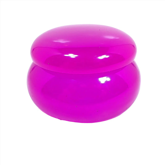 Side view of the small handmade resin decorative jar trinket box. It is neon purple in color and is round shaped with lid.