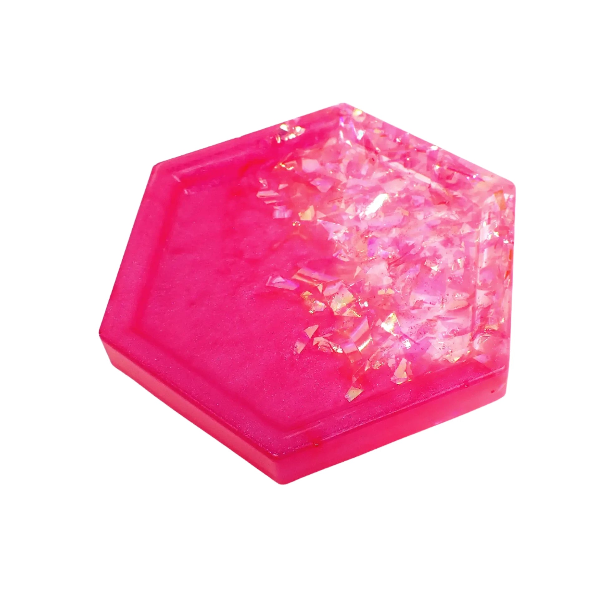 Angled view of the small handmade resin trinket dish tray. It is hexagon shaped and has bright pearly pink resin on one side and iridescent glitter flakes on the other.