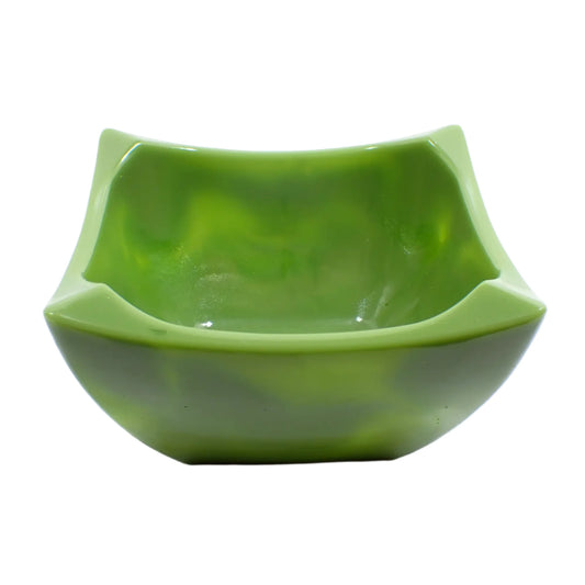 Angled view of the handmade decorative bowl. The resin is marbled in opaque olive green with pearly olive green. The bowl is square shaped with angled pinched edges for a retro style appearance.