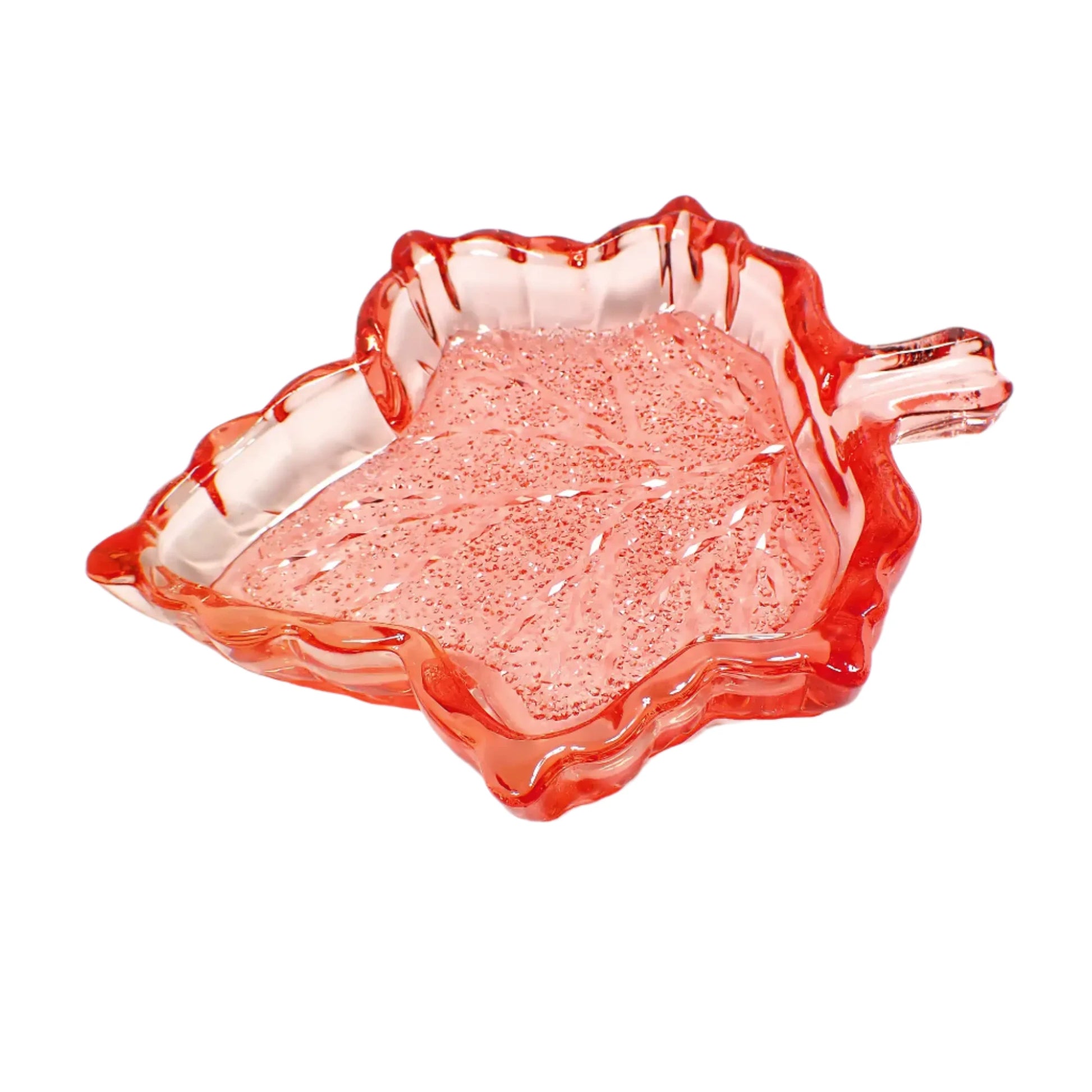 Angled view of the handmade resin leaf trinket dish. The resin is translucent red in color with hints of orange. The inside bottom of the leaf has a faceted crystal like design that sparkles in the light.