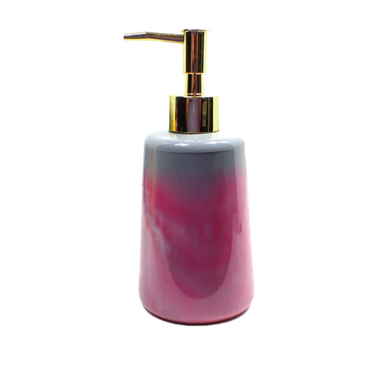 Side view of the flared round handmade soap or lotion dispenser. The photo shows this one with a metallic gold color pump top. The bottle part is round and flared on the bottom. There is gray resin on top and marbled shades of rose pink and gray on the rest of the piece.