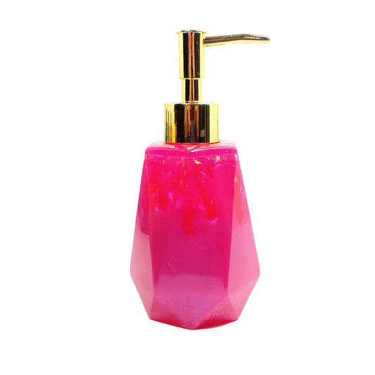 Side view of the handmade lotion soap dispenser. The photo shows it with a gold color pump top. The bottle part has neon pink resin at the top with iridescent flakes and the bottom has bright pearly pink resin.