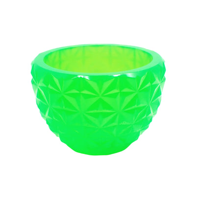 Side view of the handmade neon green resin retro style decorative bowl. It is smaller sized and looks bright neon green with hints of bright yellow. It is round in shape that tapers down to the bottom. The faceted design looks like stars all the way around the bowl.