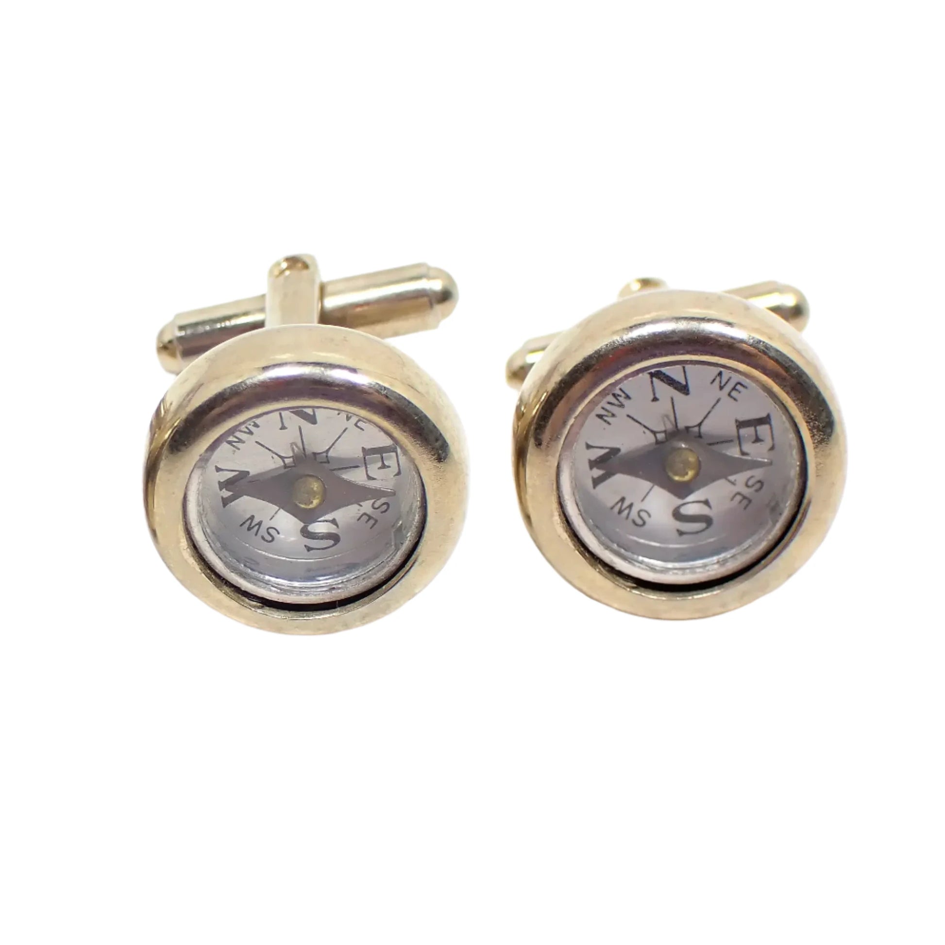 Front view of the 1950's Mid Century vintage compass cufflinks. They are round with gold tone color metal. The inside compass area is silver in color with black markings.