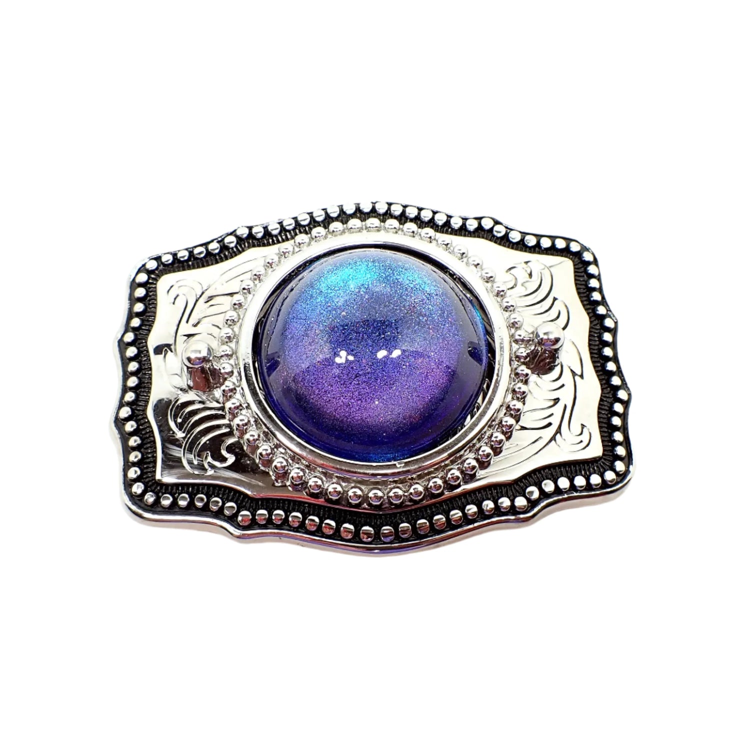 Front view of the upcycled belt buckle. The buckle is silver tone in color with a leaf design and black enameled edge. The middle cab is domed round and has color shift resin that goes from blue to purple depending on how the light hits it.