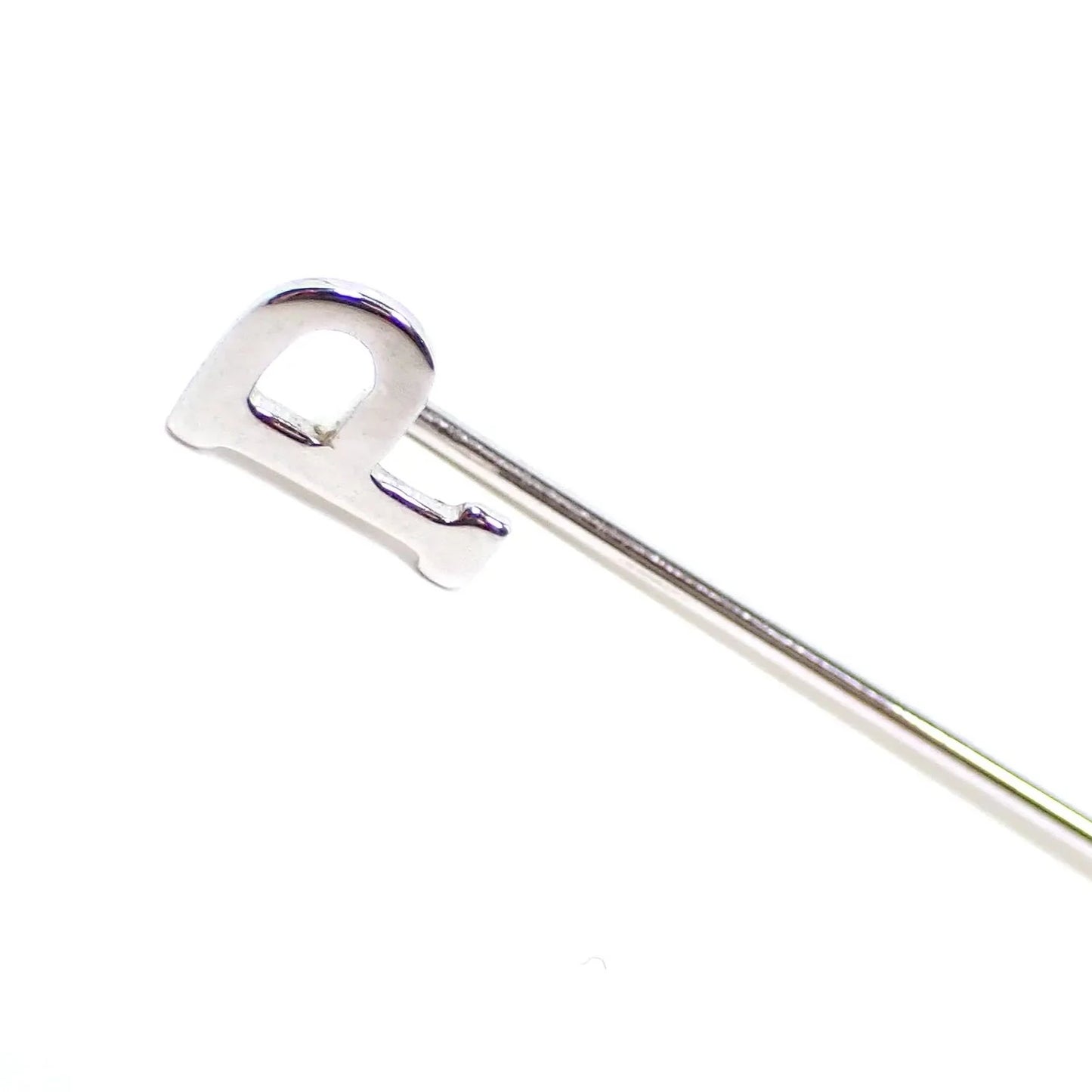 Enlarged view of the retro vintage initial lapel stick pin. It has a block style letter P at the top. The metal is silver tone in color.