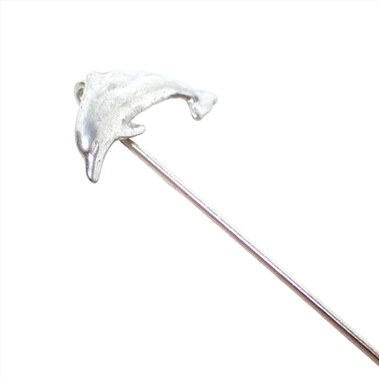 Enlarged view of the retro vintage dolphin stick pin. It is silver tone in color and has a dolphin shape at the top.