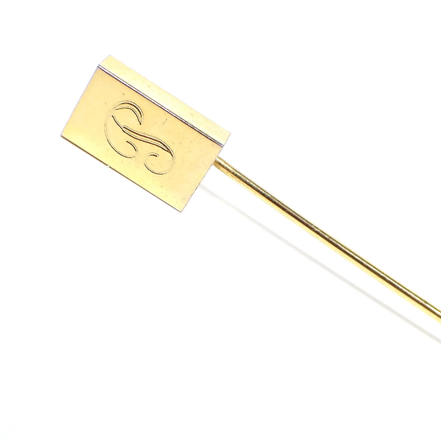 Enlarged view of the top part of the Mid Century vintage initial letter P stick pin. It is gold tone in color and has a rectangle on the top. There is a fancy script letter P engraved on the front.