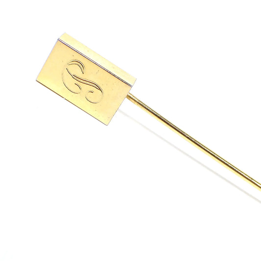 Enlarged view of the top part of the Mid Century vintage initial letter P stick pin. It is gold tone in color and has a rectangle on the top. There is a fancy script letter P engraved on the front.