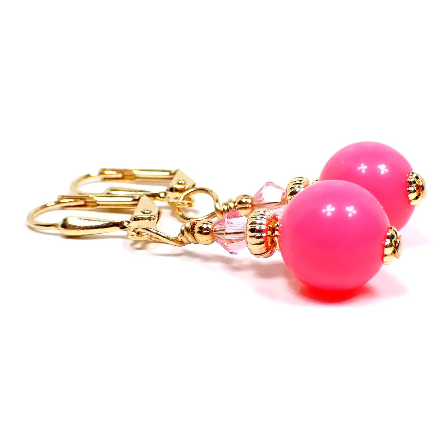 Top view of the handmade small drop earrings with vintage acrylic beads. The metal is gold plated in color. There is a faceted glass crystal bead in light pink at the top. The bottom acrylic beads are round ball shaped and are bright pink in color.