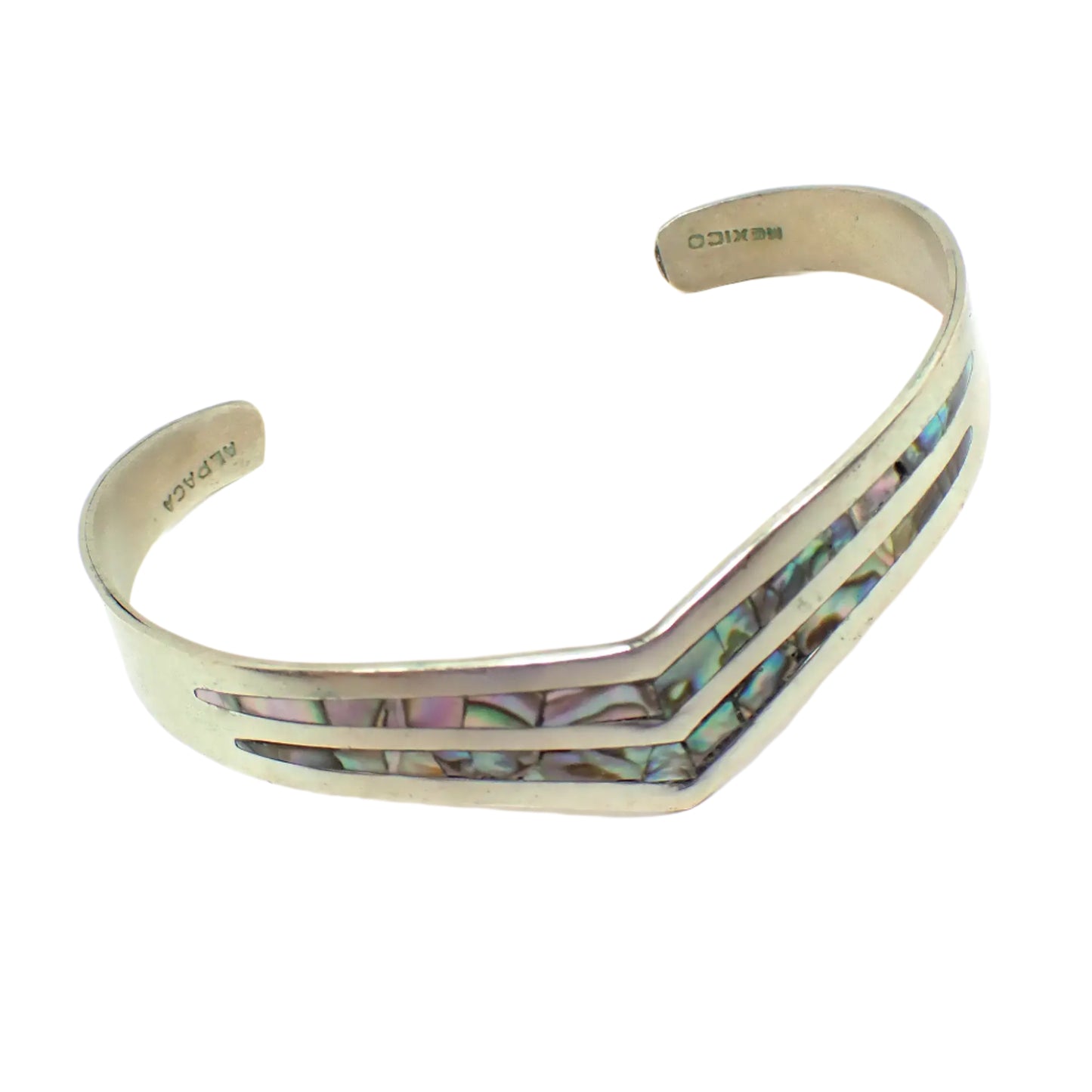 Angled view of the vintage Alpaca Mexico cuff bracelet. Here the markings can be seen on the ends as well as the iridescent colors on the abalone shell on the front.