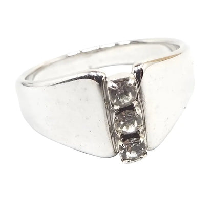 Front view of the retro vintage angled rhinestone ring. The metal is silver tone in color. There is a vertical row of three round clear prong set rhinestones on the front. The sides are flared and angled up the the rhinestones.