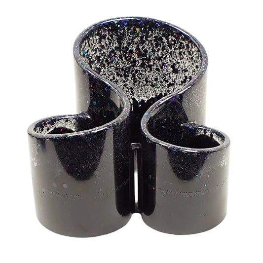 Front view of the handmade resin makeup brush holder. It has three compartments that are rounded in shape. Each is slightly taller than the other with the tallest in the back. There is black iridescent glitter at the top and a band around the middle and the rest of the piece is black in color.