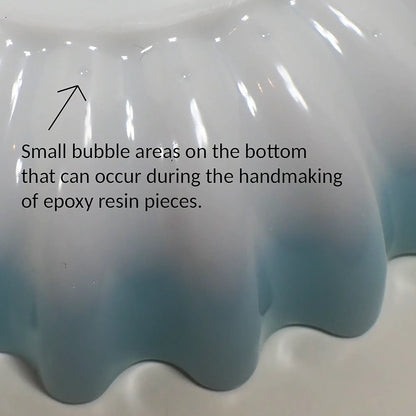 Photo with wording showing a closeup of some of the small bubble areas on the bottom of the bowl that can occur during the handmaking process.