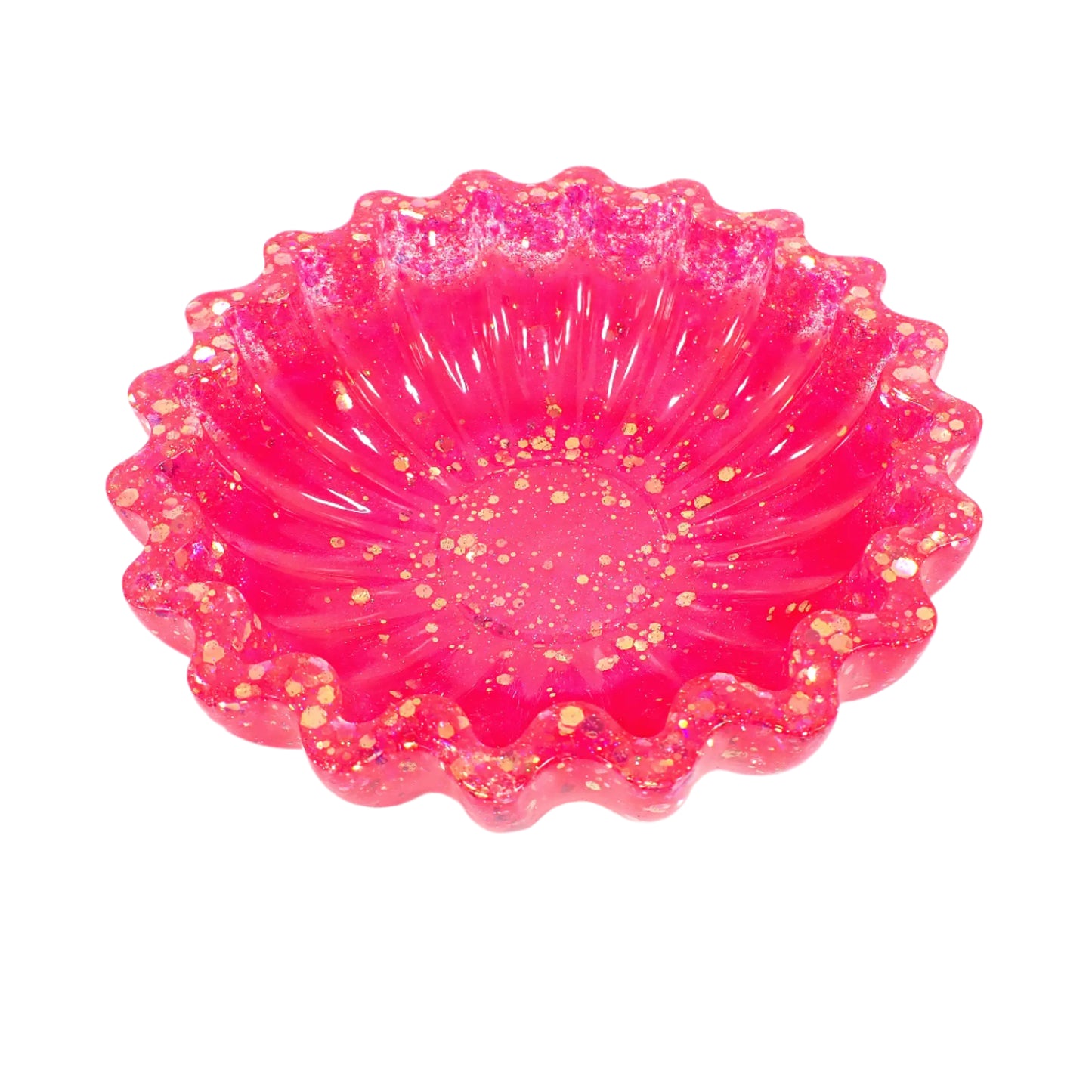 Angled view of the handmade resin scalloped bowl. The resin is a bright pearly pink in color with chunky iridescent glitter towards the top and bottom of the bowl. 