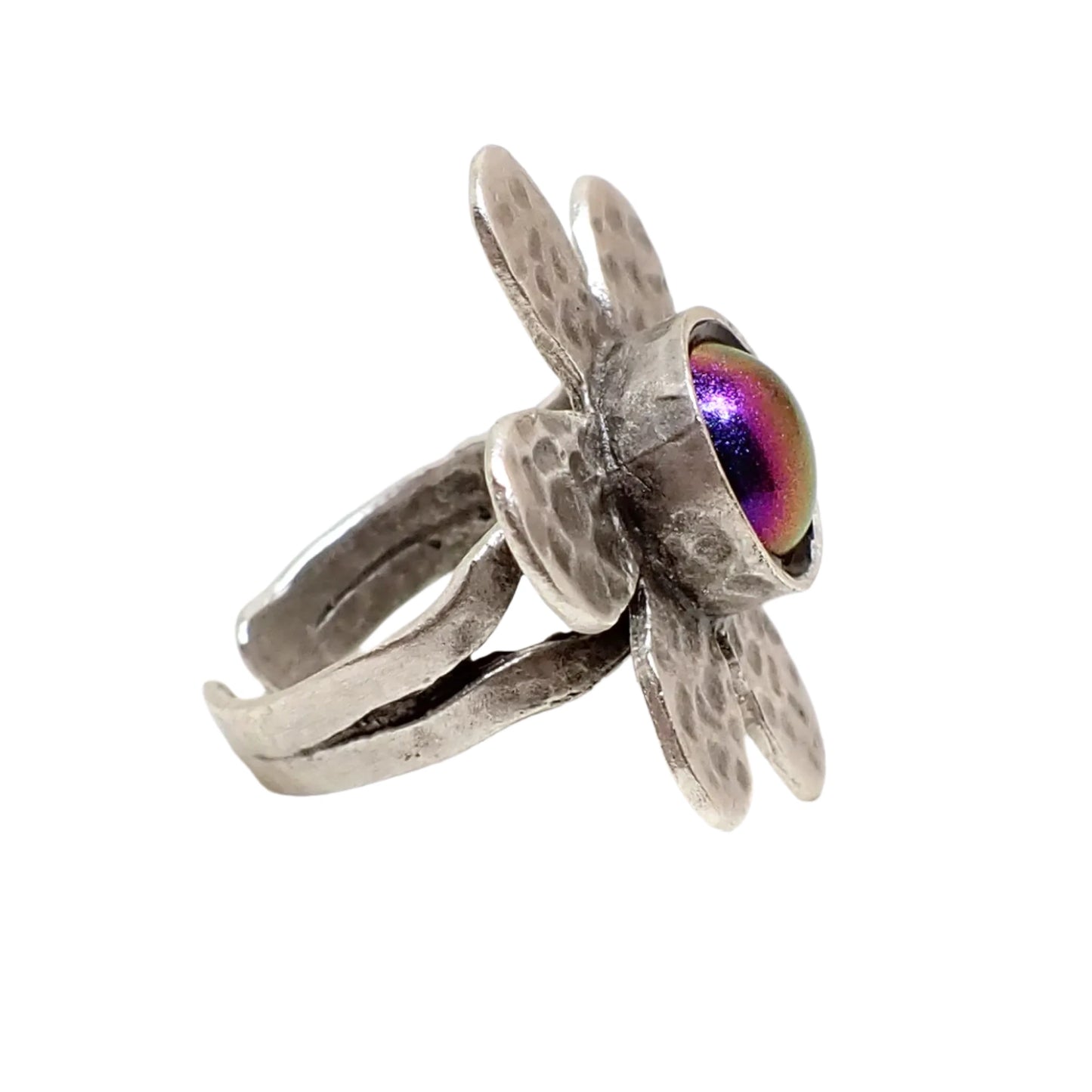 Angled side view of the color shift flower ring. Here the band can be seen and it has a split style design that goes down to curved ends.