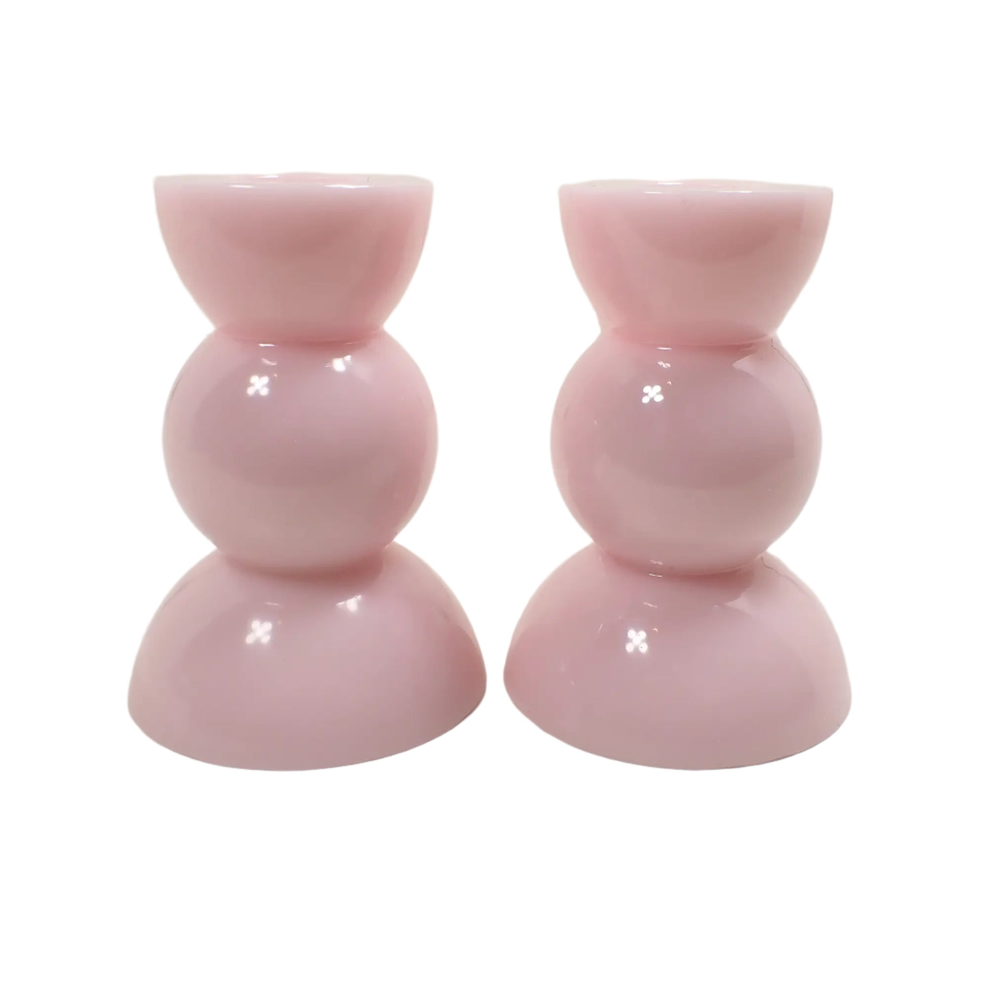 Side view of the cotton candy pink candle holders. There is a half sphere shape at the top and bottom and a round sphere shape in the middle for a geometric appearance.