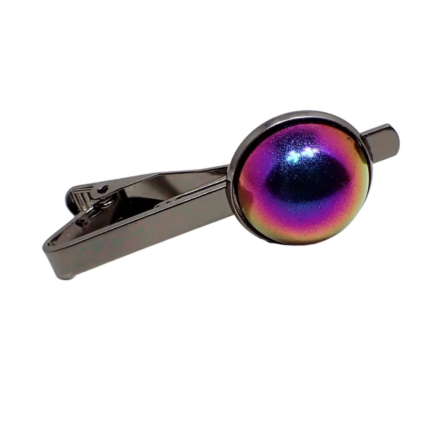 Angled front view of the tie clip. The metal is dark gray color gunmetal. There is a large domed round resin cab at the end with color shift resin that has shades of blue, purple, pink, and yellow showing.