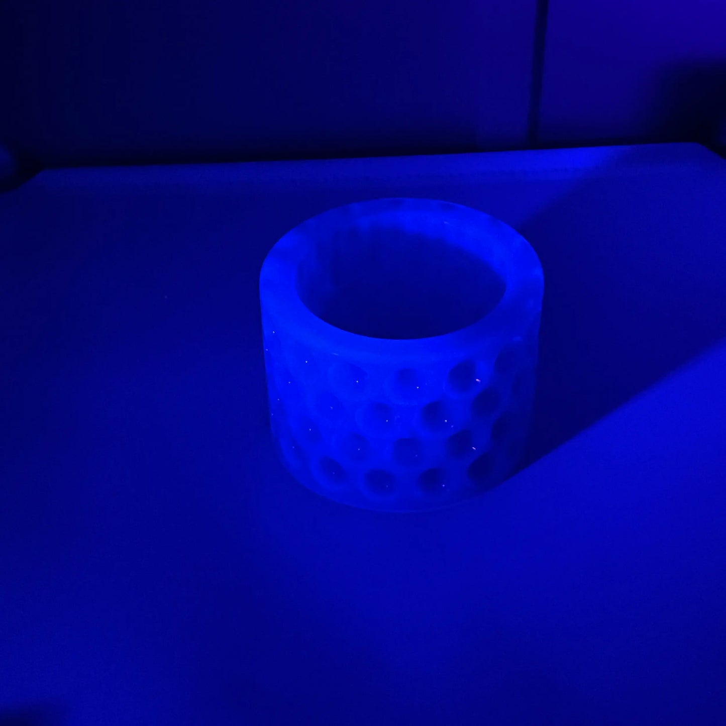 Photo showing how the decorative trinket dish fluoresces under a UV light in blue.  