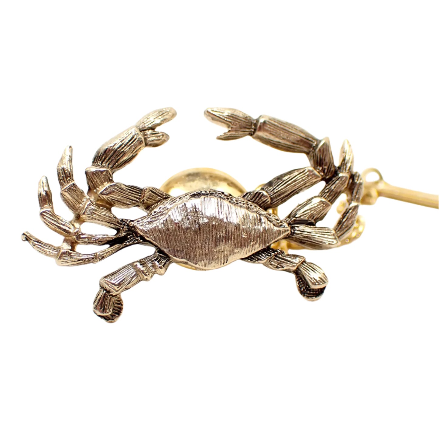 Enlarged view of the front of the Jolle vintage tie tack. It has a 3D design of a Maryland crab. The metal is textured and gold tone in color.