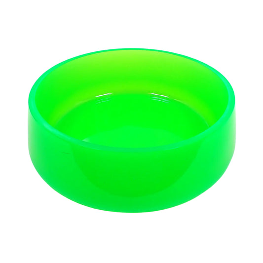 Angled side view of the large handmade neon green decorative bowl. It is round with a slightly flared bottom. The resin is smooth, shiny, and semi translucent in a bright neon green color. Great as a trinket bowl, part of a table centerpiece, or just added to your UV fluorescent decor.