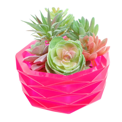 Image of the large handmade neon pink geometric bowl with a bunch of fake succulent plants displayed in it to show how it would look as a planter pot.