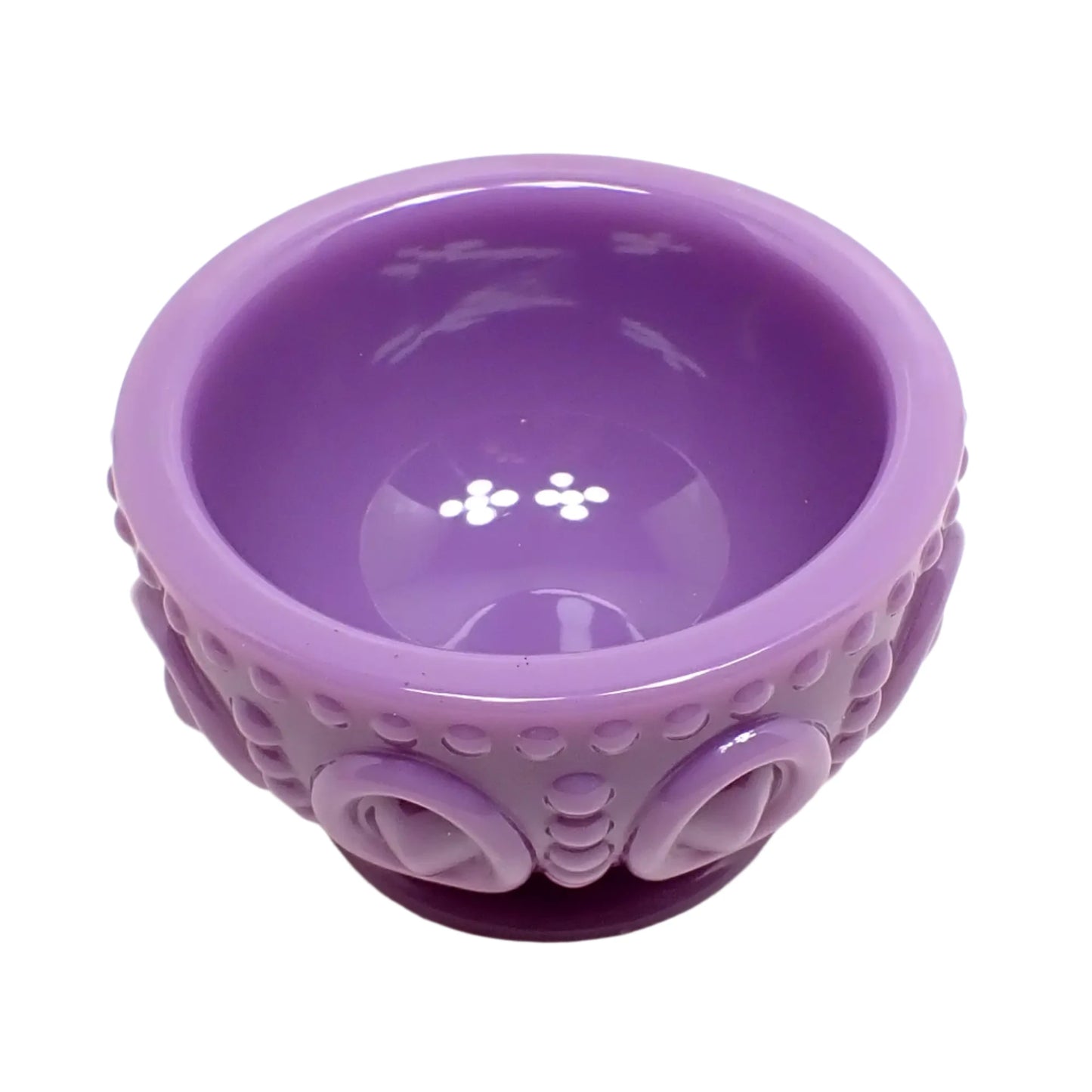 Angled top view of the light purple resin footed bowl. This angle shows the inside round opening where items can be placed.