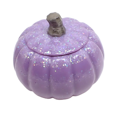 Angled photo showing the light purple pumpkin trinket box. the resin is opaque pastel purple and there is iridescent pastel glitter on the top part of the pumpkin. The stem is a light pearly brown color. 