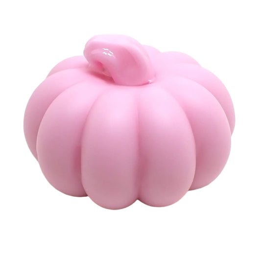 Angled view of the small resin pumpkin. The stem is shiny pink and the rest of the pumpkin is matte pastel pink. 