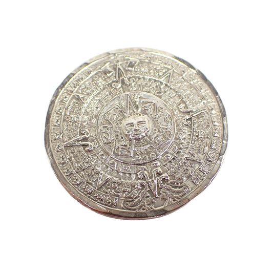 Front view of the retro vintage Mayan Calendar brooch pendant. It is round with silver tone color metal. The Mayan Calendar design is slightly raised and it has a lightly faceted edge.