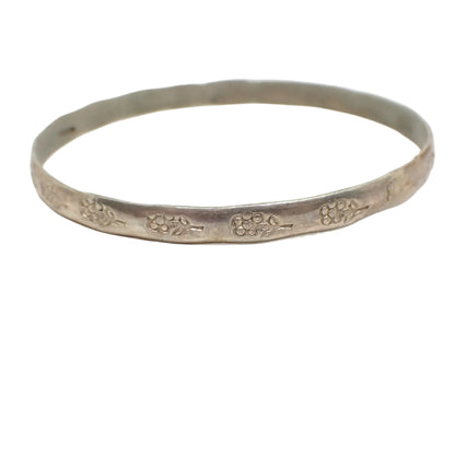 Side view of the bangle bracelet. The bangle is antiqued silver in color and it has a hammered style edge.