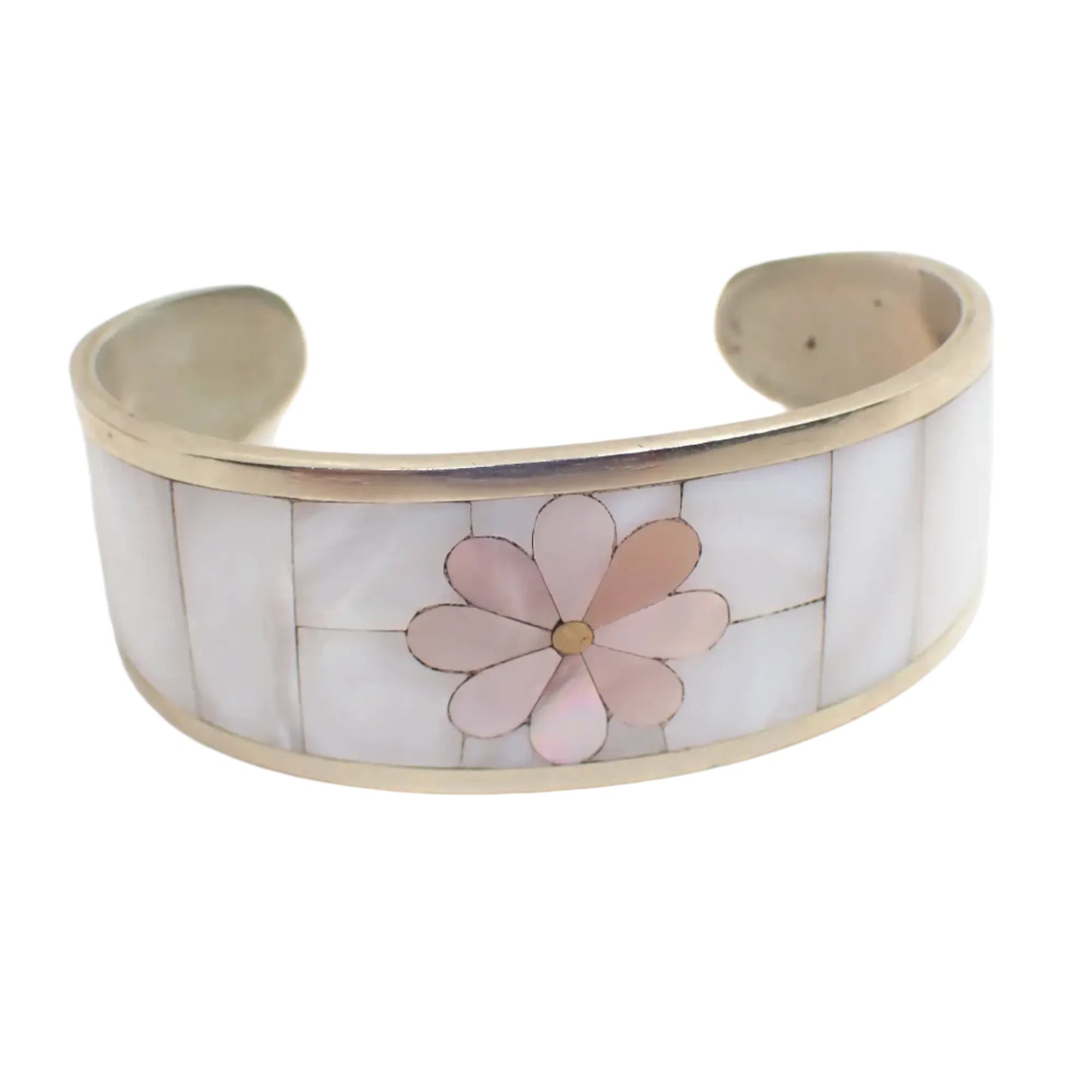 Front view of the mother of pearl vintage cuff bracelet. It is curved with pieces of pearly white mother of pearl shell all around the outside with a pink dyed mother of pearl flower design in the middle.