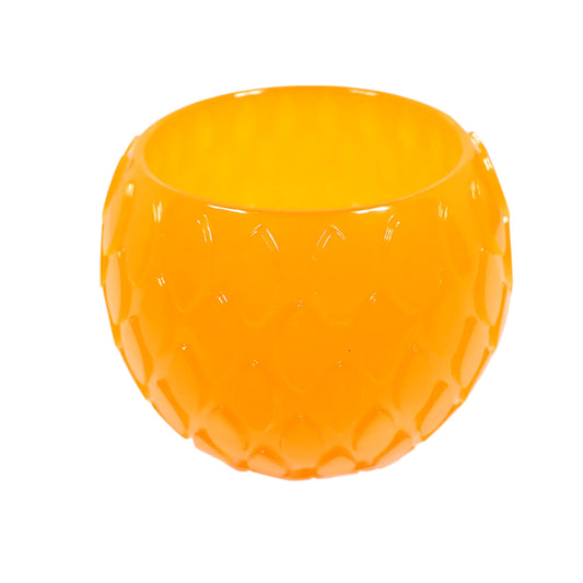 Angled side view of the handmade neon orange resin decorative bowl. It is round with a tapered bottom and has a raised marquis shape design all the way around the outside of it. The resin is shiny and semi translucent in a citrus neon orange color. Great for using as a small succulent planter pot or just to add a pop of color to your Spring and Summer home decor.